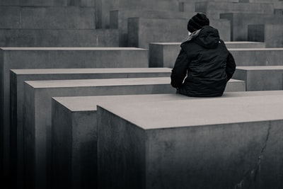灰度照片的女人坐在混凝土砌块
